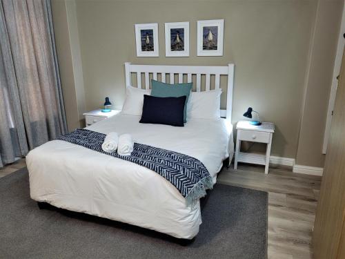 a bedroom with a large white bed with two night stands at On The Beach At Strand in Strand