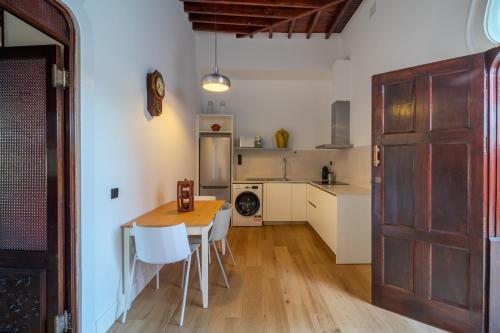 a kitchen with a table and chairs and a door at Albor Suites in Santa Brígida