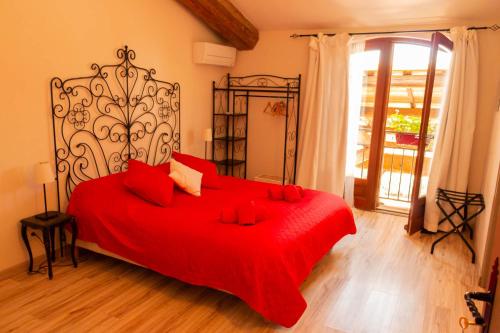 - une chambre avec un lit rouge et une couverture rouge dans l'établissement Mas Tolosan, à Vauvert