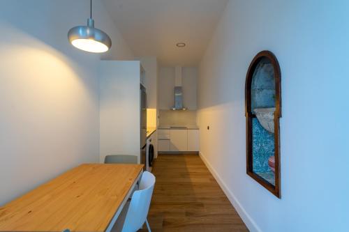 a dining room with a wooden table and a mirror at Albor Suites in Santa Brígida