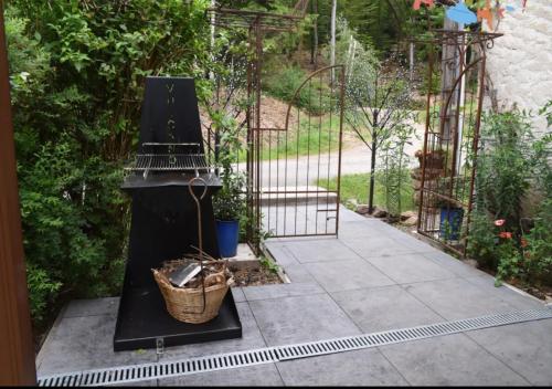a garden with a black stove with a basket at Gîte du ruisseau in Épinal