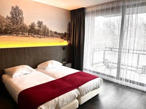 a bedroom with a bed and a large window at Golf-Resort Brunssummerheide in Brunssum