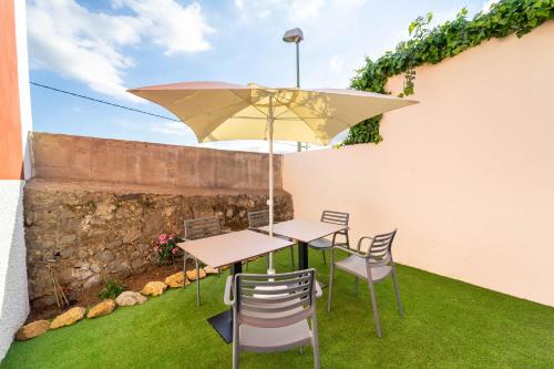 a patio with a table and chairs and an umbrella at Albor Suites in Santa Brígida