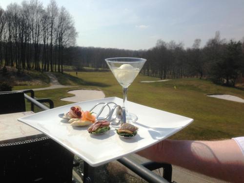 une assiette de nourriture et un verre de vin dans l'établissement Golf-Resort Brunssummerheide, à Brunssum