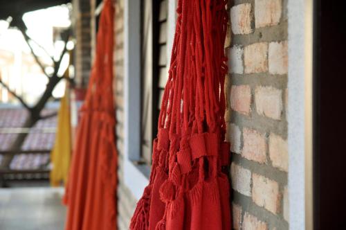 a red scarf is hanging on a brick wall at OXENTE Natal in Natal