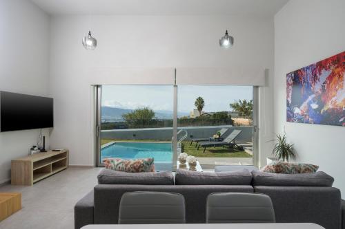 uma sala de estar com um sofá e uma piscina em Villa Jarko em Chania Town