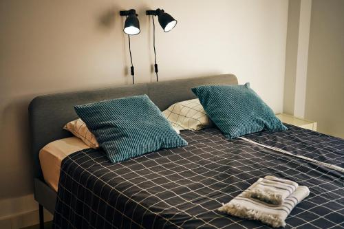 ein Bett mit blauen Kissen und einem Handtuch darauf in der Unterkunft 3BDR + 2BATH OCEAN VIEW APARTMENT in Santa Cruz de Tenerife