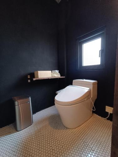 a bathroom with a toilet and a window at 山茶雅舍 新北市民宿證號360號 in Jiufen