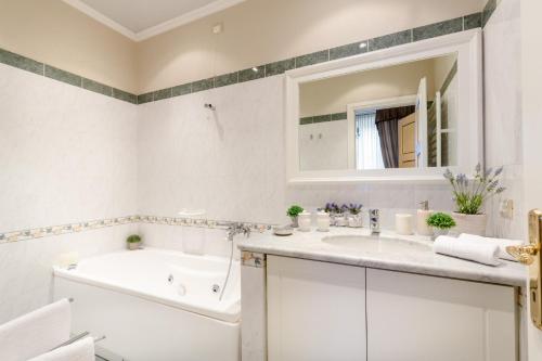 La salle de bains blanche est pourvue d'une baignoire et d'un lavabo. dans l'établissement Casa Al Giardino, à Lucques