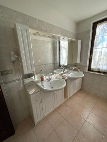 a bathroom with two sinks and a shower at Mezzanetti in Quassolo