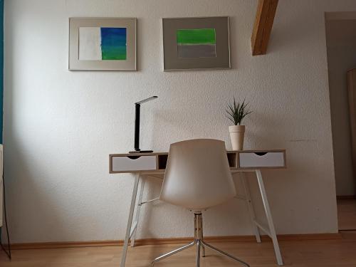 a desk with a chair and a lamp in a room at Zwischen Bauhaus und Park Georgium in Dessau