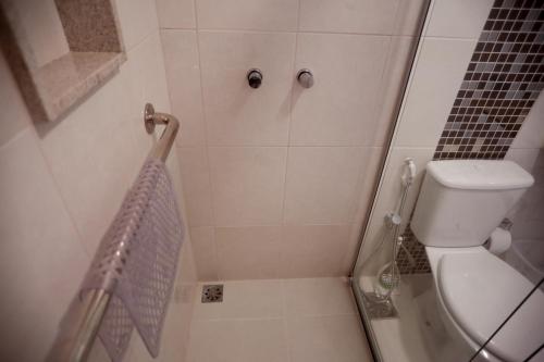 a small bathroom with a shower with a toilet at Flats Martinez in Conservatória