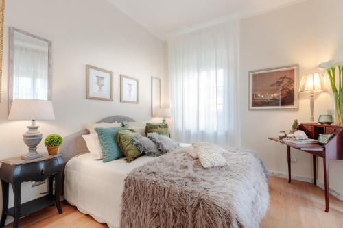 - une chambre avec un lit blanc et une couverture chauffante dans l'établissement CASA BRUMAR, the Most Central Terrace inside the Walls of Lucca, à Lucques