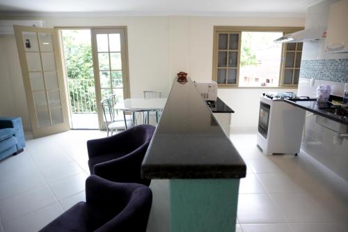 a kitchen with a counter and chairs in it at Flats Martinez in Conservatória