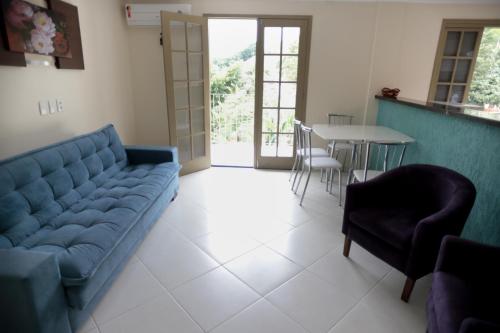 a living room with a blue couch and a table at Flats Martinez in Conservatória