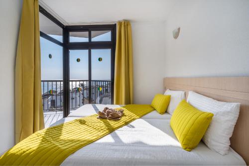プラヤ・デル・イングレスにあるRT-Apartamentos Guineaのベッドルーム1室(黄色い枕のベッド1台、窓付)