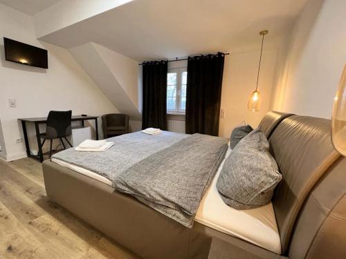a bedroom with a large bed and a desk at Pension-Sendis in Herne