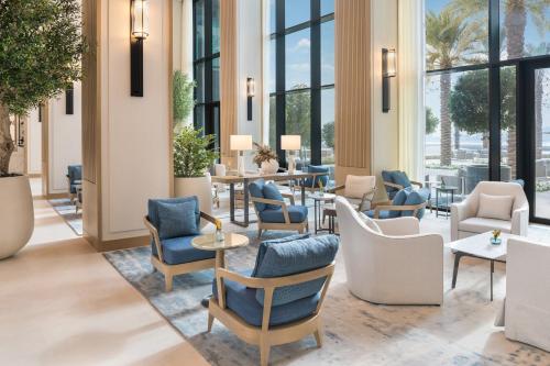 a lobby with chairs and tables and windows at Vida Beach Resort Marassi Al Bahrain in Manama