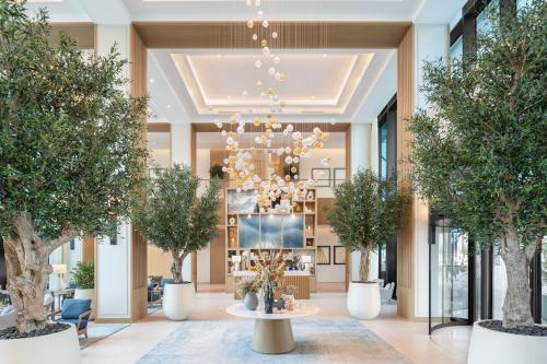 a lobby with trees and a chandelier at Vida Beach Resort Marassi Al Bahrain in Manama