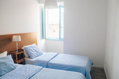 two beds in a hotel room with a window at Xicotina in Moledo