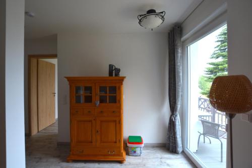 a room with a wooden cabinet and a large window at Urlaub am Plätlinsee Haus Rike in Wustrow