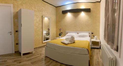 a bedroom with a large bed with a yellow blanket at Antica Locanda Zio Cesare in Ferrara