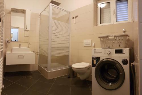a bathroom with a toilet and a washing machine at Villa Radoš - 4 Sterne, 3 Apartments für maximal 18 Gäste in Supetar