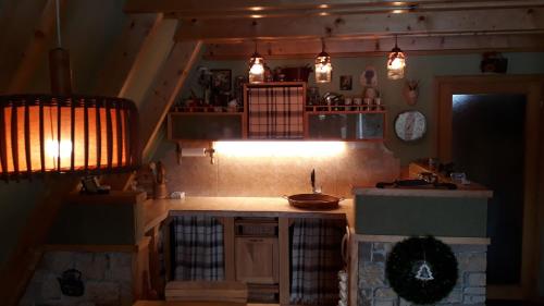 eine Küche mit einem Waschbecken und Lampen in einem Zimmer in der Unterkunft Tarski Proplanak in Bajina Bašta