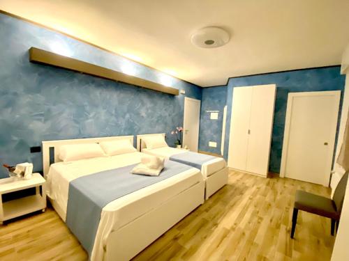a bedroom with two beds and a blue wall at Antica Locanda Zio Cesare in Ferrara