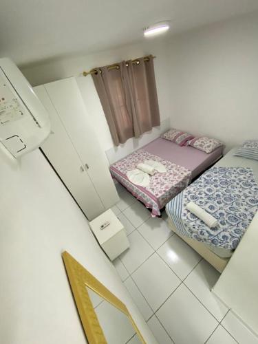 ein kleines Zimmer mit zwei Betten und einem Spiegel in der Unterkunft PRAIA RESIDENCE Rua Cajueiro in Ipojuca
