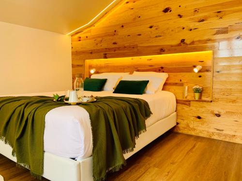 Furnas Spring Lodge في فورناس: غرفة نوم بسرير كبير وبجدار خشبي