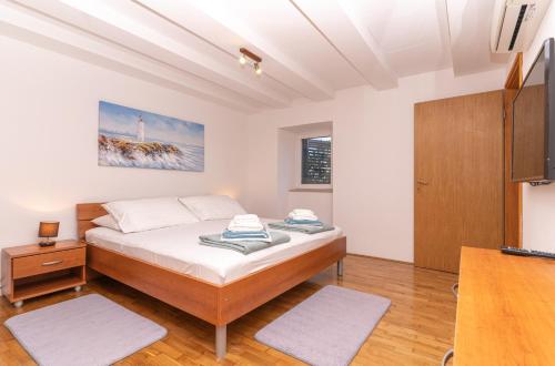 um quarto com uma cama e um armário de madeira em Villa Luic em Čilipi