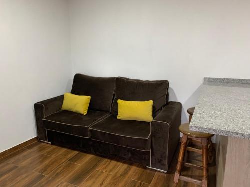 a black couch with two yellow pillows in a room at Casa do Julien Mountain Experience in Vila Real