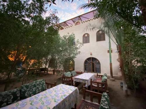an outdoor patio with tables and chairs in front of a building at Nour El Balad in Luxor