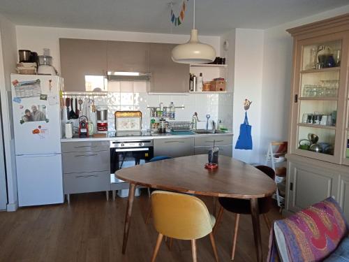 een keuken met een houten tafel en een koelkast bij Appartement Cosy Terrasse vue Quai Canal + parking in Sète