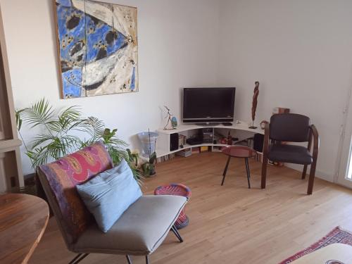een woonkamer met een tv en 2 stoelen bij Appartement Cosy Terrasse vue Quai Canal + parking in Sète