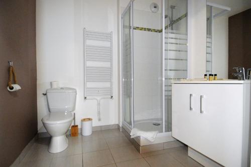 a white bathroom with a toilet and a shower at Jardin - à 50m de la plage - Wifi - Parking in Courseulles-sur-Mer