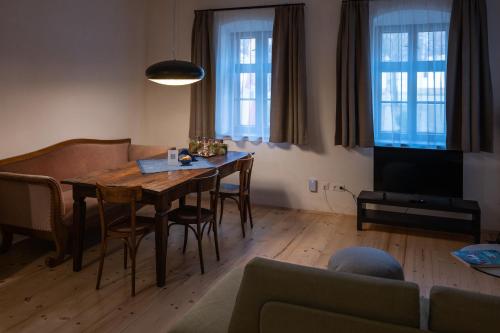 sala de estar con mesa, sillas y TV en Tschardakenhof Appartements, en Lutzmannsburg