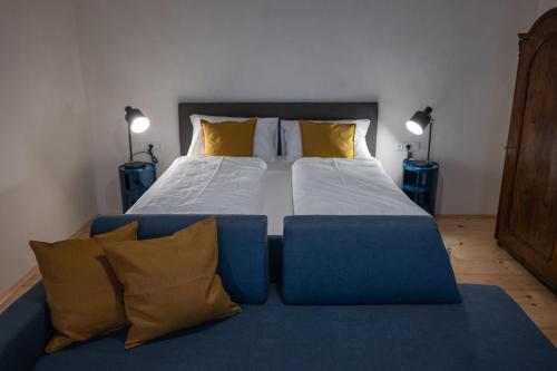 a bedroom with a blue bed with yellow pillows at Tschardakenhof Appartements in Lutzmannsburg