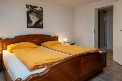 ein Schlafzimmer mit einem Holzbett mit gelber Bettwäsche in der Unterkunft Schusters Haus in Boppard