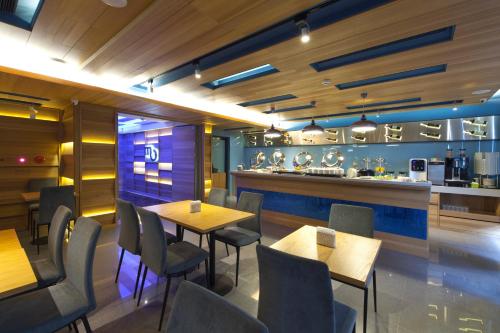 a restaurant with tables and chairs and a bar at Hotel MU in Zhongli