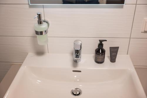 a white bathroom sink with two bottles on it at Tschardakenhof Appartements in Lutzmannsburg
