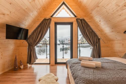 a bedroom with a bed and a large window at Domek Zakopiański Czar in Zakopane