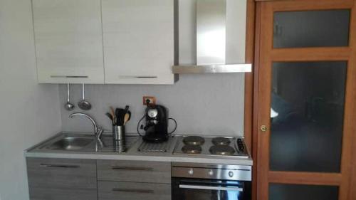een keuken met een wastafel en een fornuis top oven bij La casa di Ester in Lavagna
