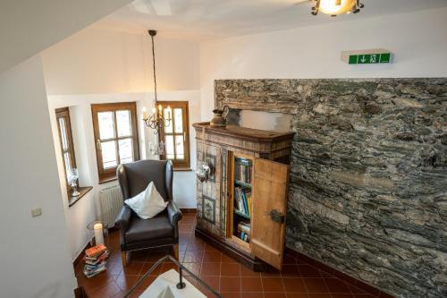 a room with a chair and a stone wall at Naturhotel Hüttenwirt im Grossarltal in Hüttschlag