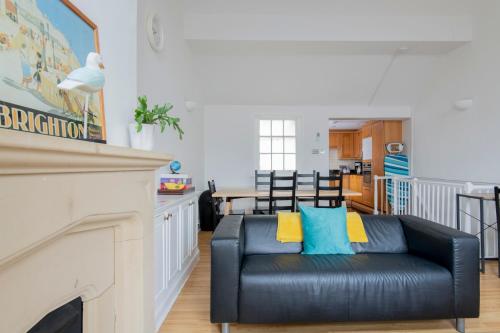 a living room with a black leather couch and a fireplace at Fantastic 3 Bed Brighton House- Sleeps 6- SUPERFAST WiFi and Garage in Brighton & Hove