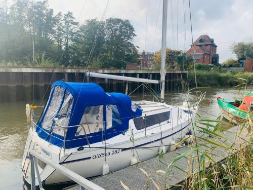 サンドウィッチにあるCosy Sailing Boat Glamping Accommodation on the River in Sandwichの船が水上の桟橋に停泊