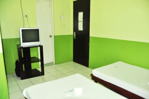 a green and white room with a tv and a bed at GV Hotel - Lapu-Lapu City in Mactan