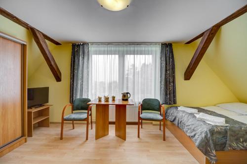 ティリチにあるOśrodek Wypoczynkowy BARTAのベッドルーム1室(ベッド1台、テーブル、椅子付)
