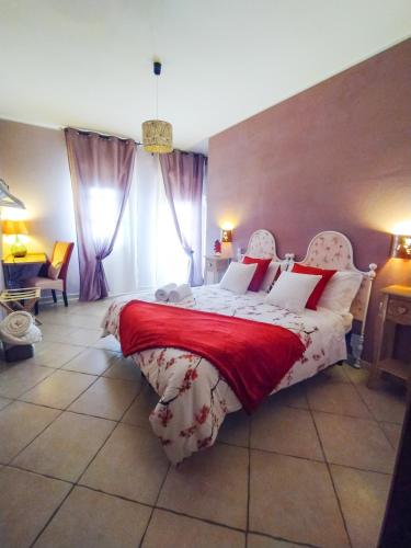 a bedroom with a large bed with a red blanket at Il Sentiero B&Bìo in SantʼAntìoco